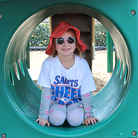 Sun safe girl in playground tunnel